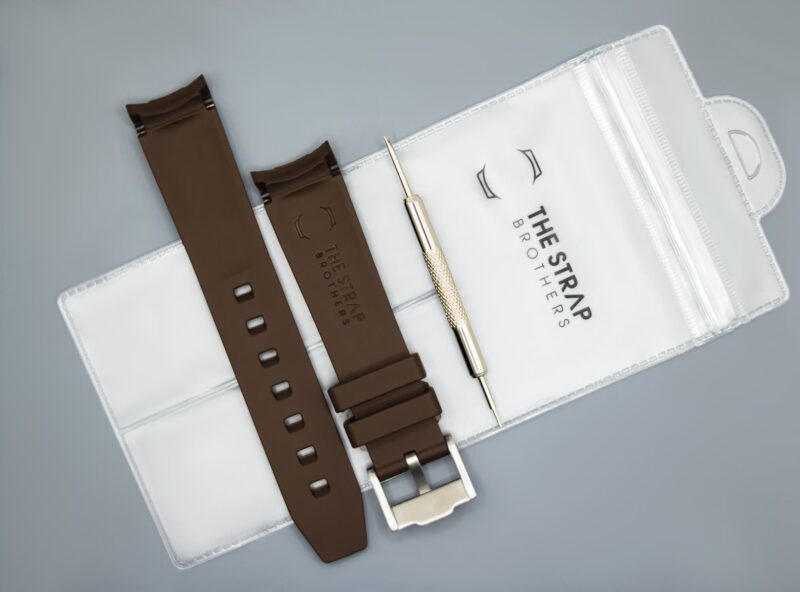 Achterzijde van het bruine MoonSwatch horlogebandje en verpakking van The Strap Brothers
