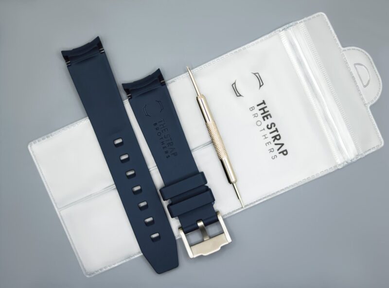 Achterkant van het donkerblauwe MoonSwatch horlogebandje en de verpakking van The Strap Brothers