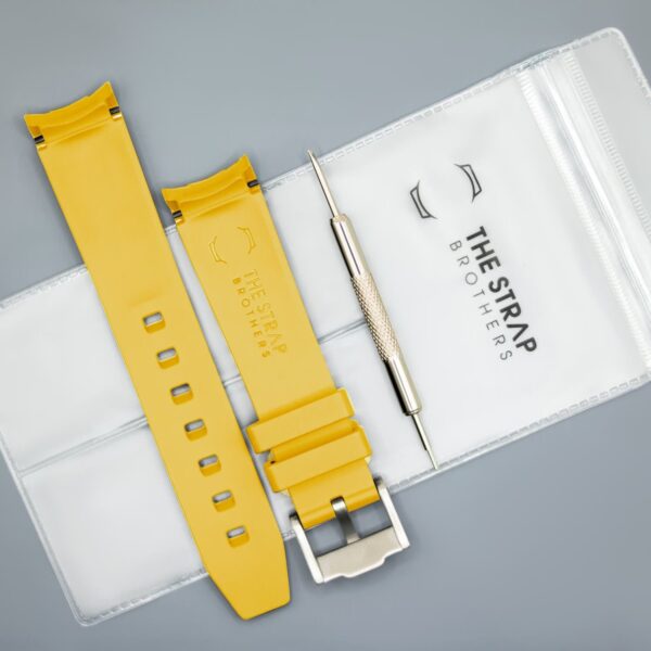 Achterkant van het Yellow MoonSwatch horlogebandje en verpakking van The Strap Brothers